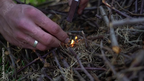Setting fire to a pile of dry branches with matches. Man strikes a match