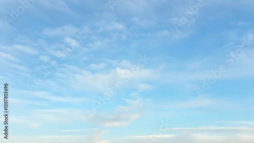 Fototapeta Naklejka Na Ścianę i Meble -  Light Blue Vault of Heaven, Filmy Clouds Wandering. The light blue sky is pure and vast. A few filmy clouds float leisurely, as if dancing gently, adding a touch of leisure and agility to the boundles