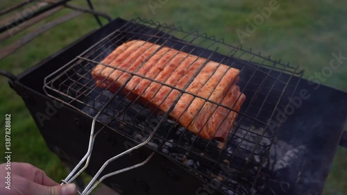 Covering a piece of meat with a grill. Roasting meat on the grill