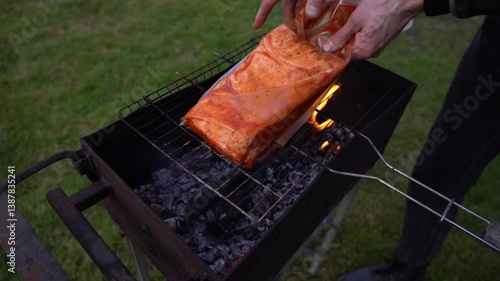 Putting a fresh piece of ribs on the grill. Roasting ribs on the grill
