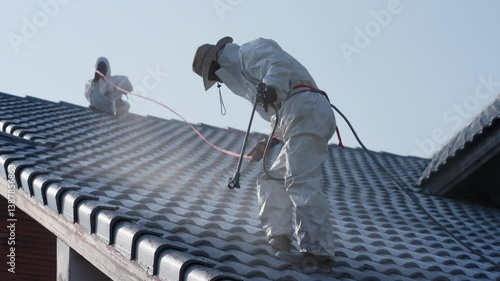 Professional painter on roof Working at heights is dangerous.	