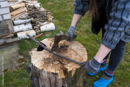 Cutting branches on the deck. A girl cuts a branch with an axe