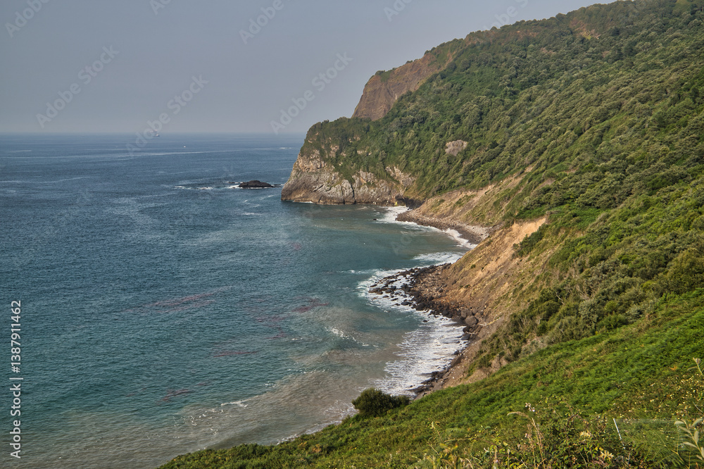 View of Cape Machichaco on a summer day with calm sea, in the Biscayan town of Bermeo, in the Basque Country, Spain. Concept destinations, travel, coast. View of Cape Machichaco on a summer day with calm sea, in the Biscayan town of Bermeo, in the Basque Country, Spain. Concept destinations, travel, coast.