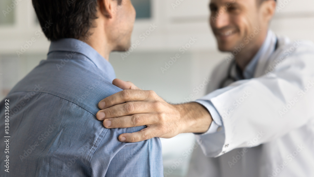 Smiling doctor in uniform speaking with male patient, touches his shoulder as gesture of encouragement, care and compassion, share good news about disease recovery, provide emotional support, close up Smiling doctor in uniform speaking with male patient, touches his shoulder as gesture of encouragement, care and compassion, share good news about disease recovery, provide emotional support, close up