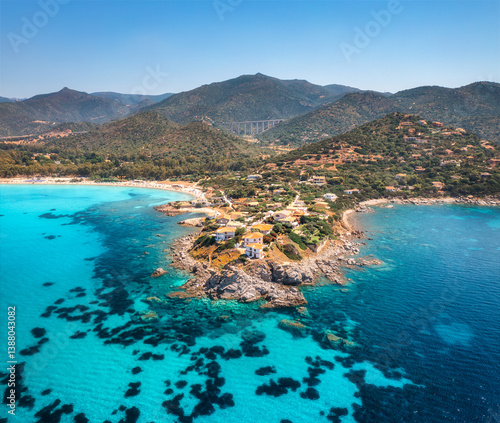 Aerial view of island, sea bay, beach, boats at summer sunny day. Travel in Sardinia, Italy. Top view from above of rocky coast, mountain, village, sea lagoon, transparent azure water, sky. Seascape