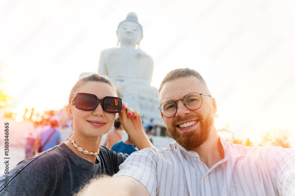 Couple taking selfie with golden buddha statue at Phuket, Thailand Couple taking selfie with golden buddha statue at Phuket, Thailand