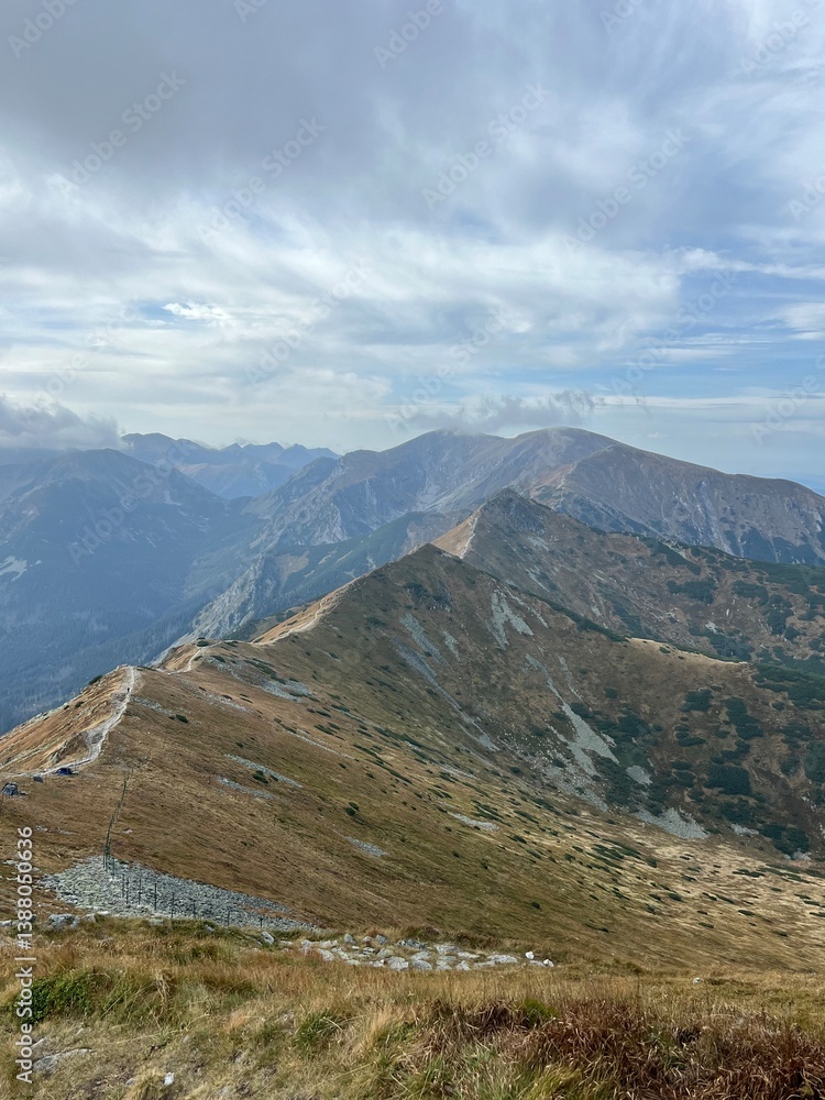 Fototapeta premium A Majestic and Stunning Mountain Range Under a Dramatic Cloudy Sky in Natures Beauty
