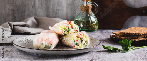 Obraz na płótnie Spring rolls in rice paper with crab sticks, cucumber, greens and sauce on a plate on web banner w salonie
