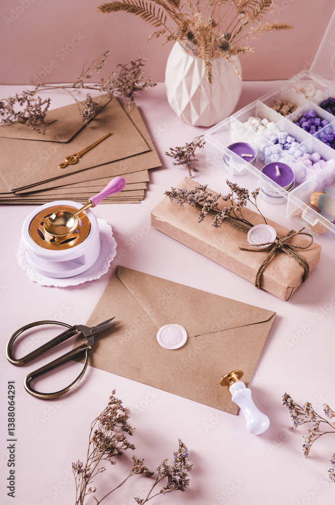 Craft envelope with wax seal and crafting items on pink vertical view