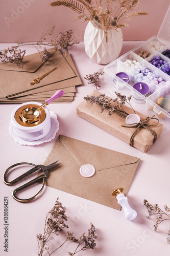 Obraz na płótnie Craft envelope with wax seal and crafting items on pink vertical view w salonie