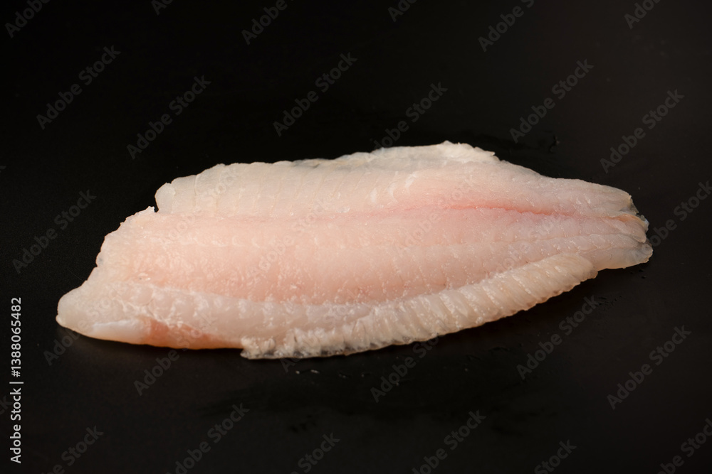 Fresh tilapia fillet on black background, top view. Fresh tilapia fillet on black background, top view.