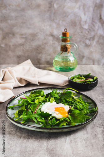Poached egg in arugula and chard leaves on a plate on a table vertical view