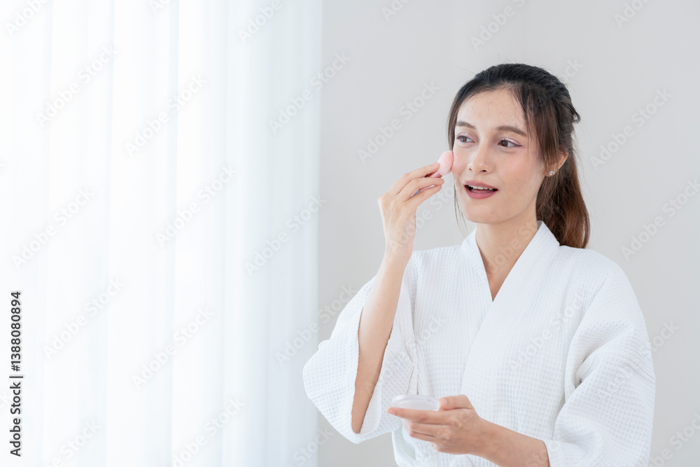 woman beauty concept,young pretty woman in bathrobe using cosmetic brush applying on cheek,with copy space for text woman beauty concept,young pretty woman in bathrobe using cosmetic brush applying on cheek,with copy space for text