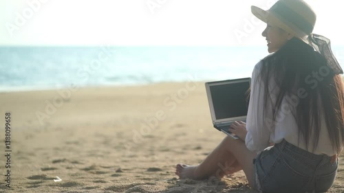 Young freelance women working with her laptop on holiday at the beach .