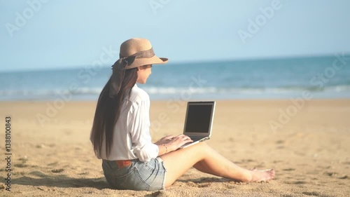Young freelance women working with her laptop on holiday at the beach .