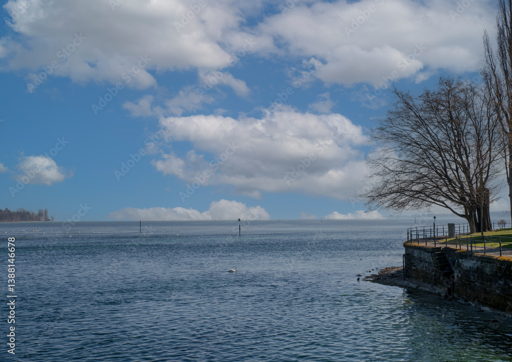 Calm waters and cloudy skies at lakeside park in early afternoon Calm waters and cloudy skies at lakeside park in early afternoon