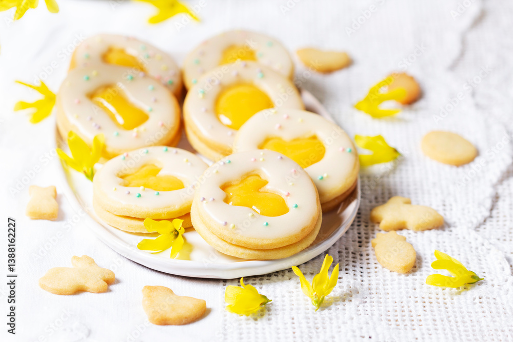Easter egg cookies with lemon orange curd, covered with white icing and forsythia flowers.