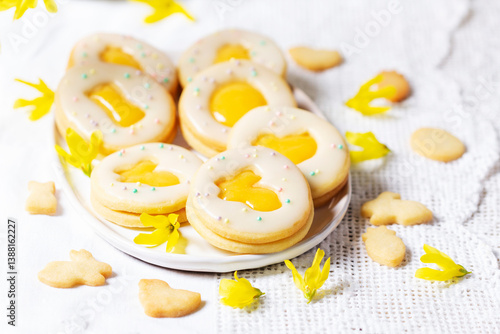 Obraz na płótnie Easter egg cookies with lemon orange curd, covered with white icing and forsythia flowers. w salonie