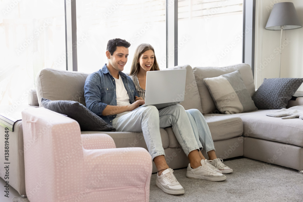 Latin couple sit with laptop on comfortable modern sofa in cozy living room, enjoying relaxation and internet usage. Booking trip, searching for flights or vacation rentals, make orders, buying goods Latin couple sit with laptop on comfortable modern sofa in cozy living room, enjoying relaxation and internet usage. Booking trip, searching for flights or vacation rentals, make orders, buying goods