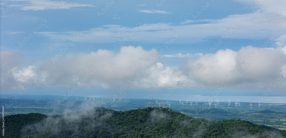 Naklejka premium Panorama of green valley with windmill turbine