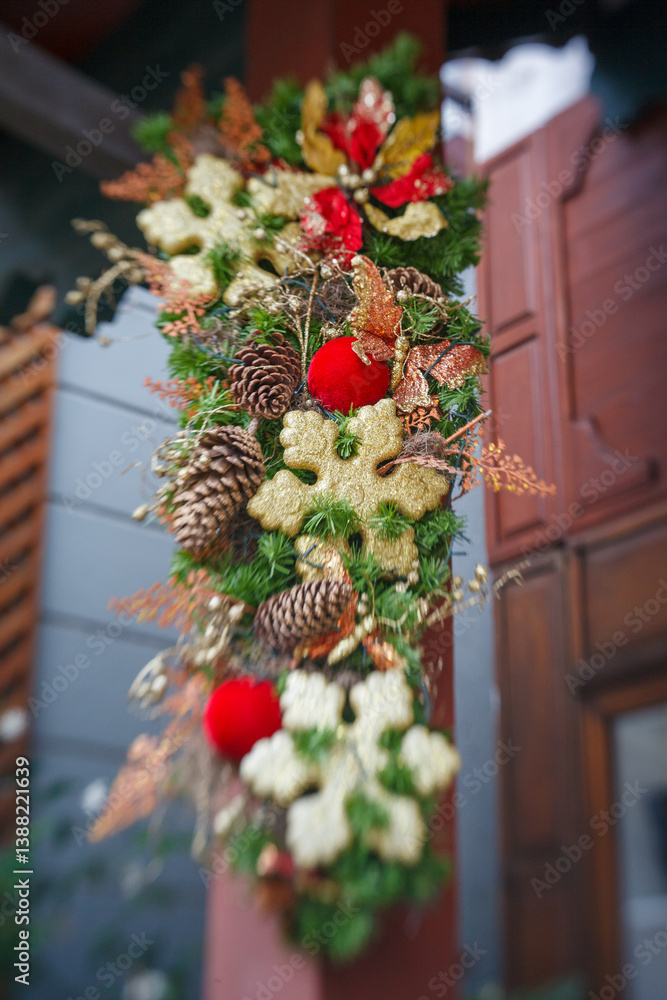 Christmas decoration wreath hangin on a wall with christmas balls, stars and pine cones.