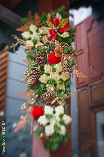 Obraz na płótnie Christmas decoration wreath hangin on a wall with christmas balls, stars and pine cones. w salonie