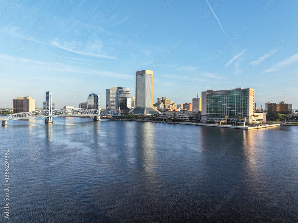 Obraz premium Cityscape view from San Marco and downtown Jacksonville, Florida, on a beautiful blue-sky spring day, with the river, John T. Alsop Jr. Bridge, and tall buildings.