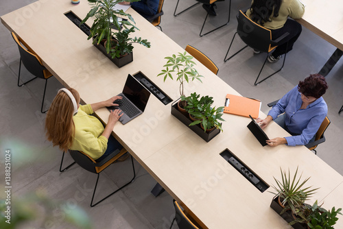 Aerial view of  multiracial and multigenerational colleagues working in modern coworking space
