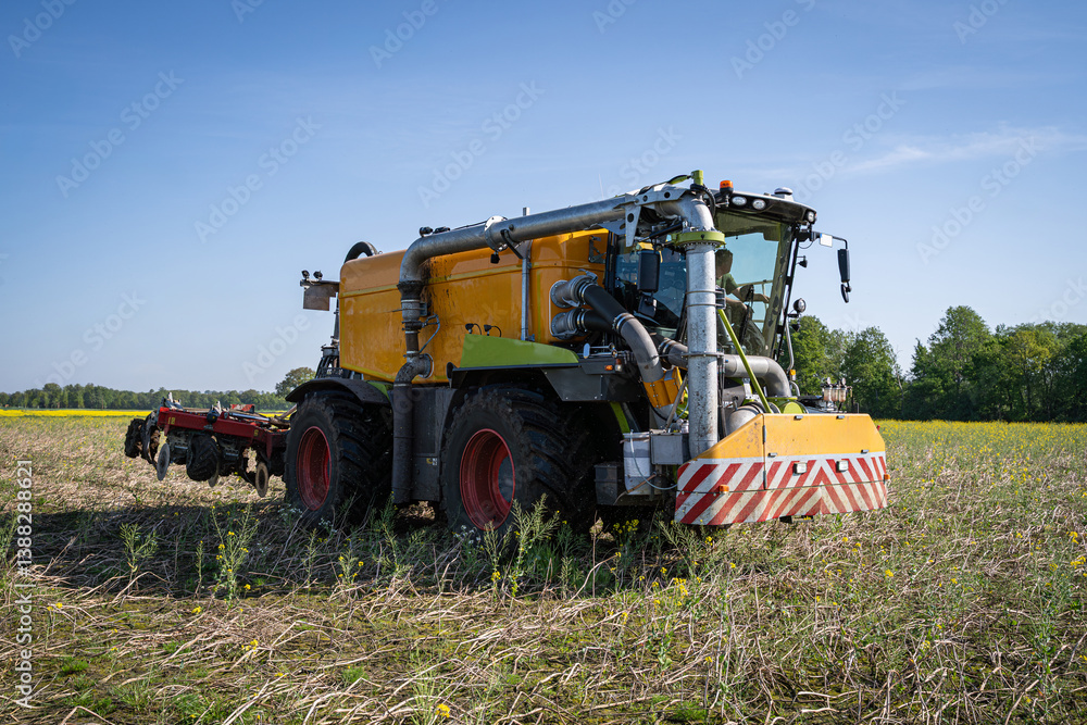 Fototapeta premium Ein Gülle Selbstfahrer Fahrzeug bei Gülleausbringung und direkter Einarbeitung in den Boden im Einsatz.