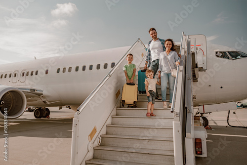 Bild auf Leinwand A joyful and happy family disembarks from a large airplane, eagerly ready for th