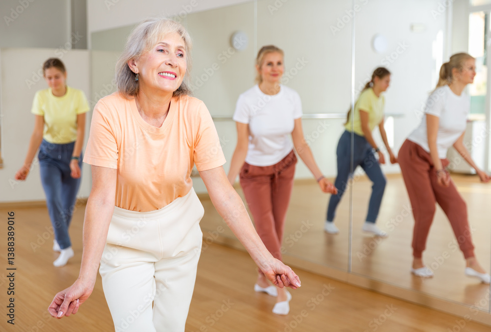 Ordinary active females exercising dance moves in dance center Ordinary active females exercising dance moves in dance center