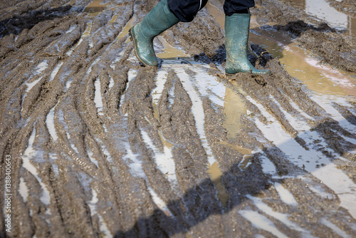 Man with boots walking in the mud