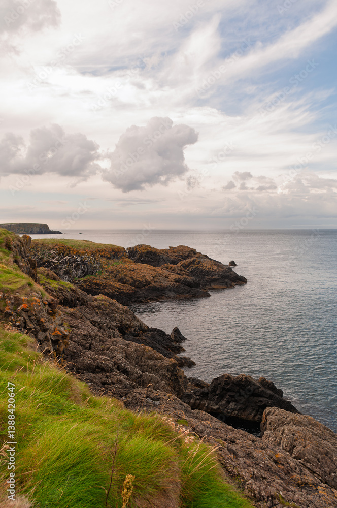 Naklejka premium A rocky shoreline with a cloudy sky in the background
