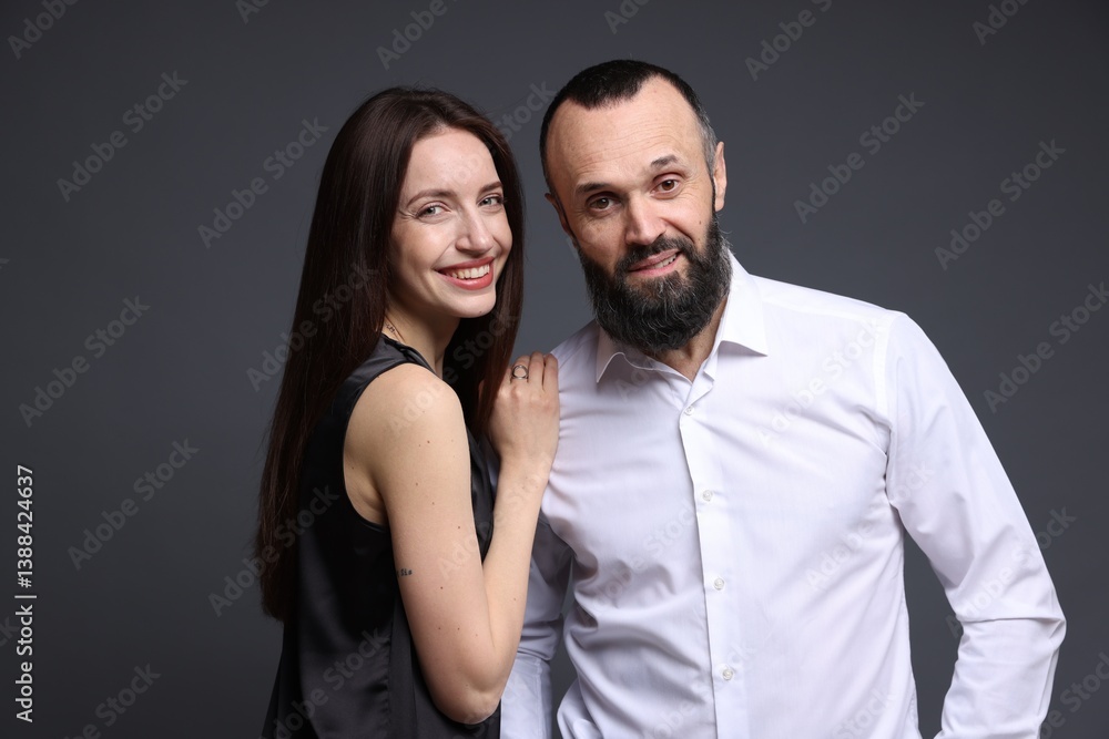 Obraz premium Portrait of happy daughter and father on dark grey background