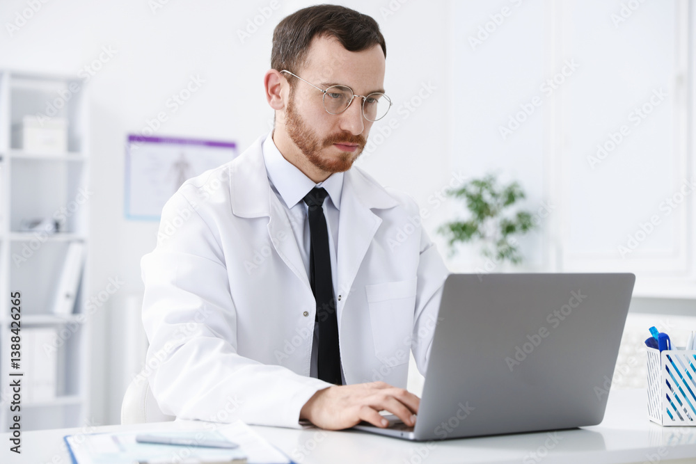 Professional doctor working on laptop at desk in hospital Professional doctor working on laptop at desk in hospital