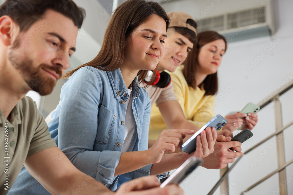 Internet addiction. Group of people with smartphones on stairs indoors Internet addiction. Group of people with smartphones on stairs indoors