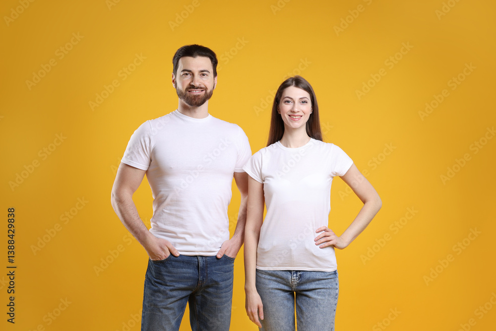 Woman and man wearing blank white t-shirts on orange background. Mockup for design Woman and man wearing blank white t-shirts on orange background. Mockup for design