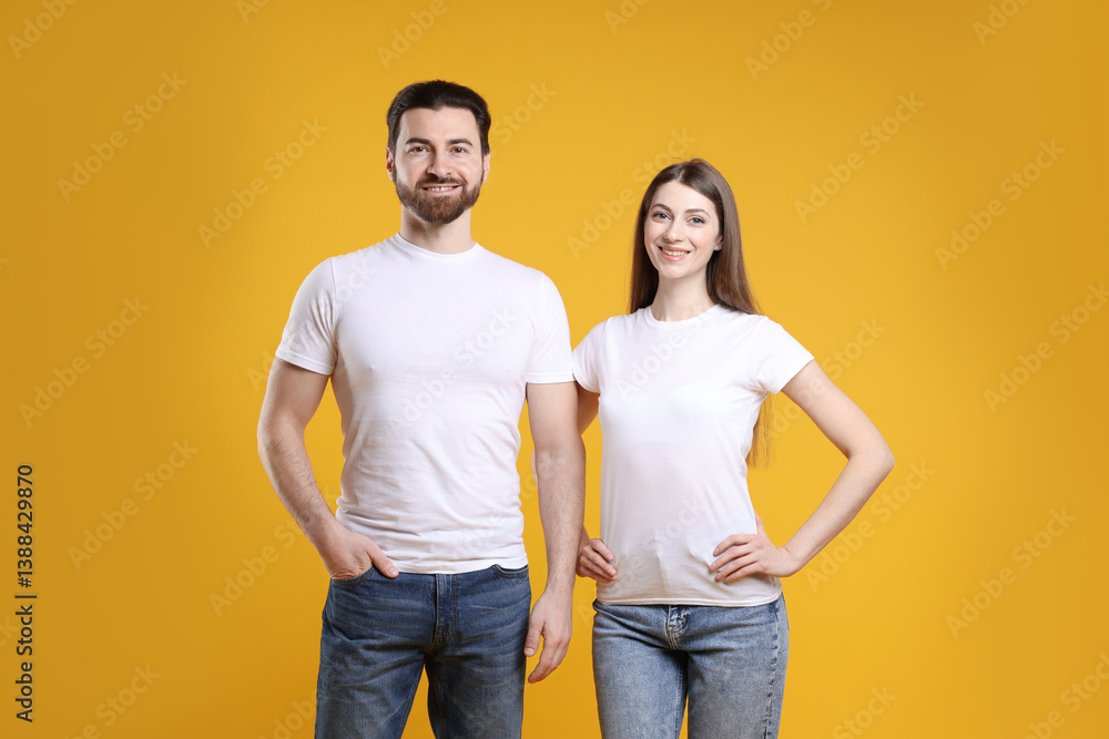 Woman and man wearing blank white t-shirts on orange background. Mockup for design Woman and man wearing blank white t-shirts on orange background. Mockup for design