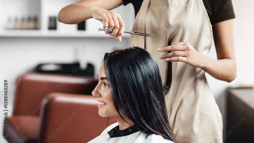 Fototapeta premium Hair treatment. Close up portrait of happy woman getting cut of split ends at hairdresser's
