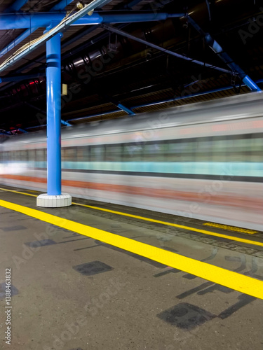 Obraz na płótnie Train platform in Jakarta appears clean and orderly, a passenger train is stopped, yellow safety line clearly visible, bright lights illuminate the area, overall calm and organized atmosphere. w salonie