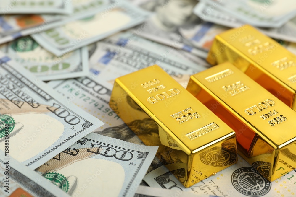 Shiny gold bars on dollar banknotes, closeup. Space for text Shiny gold bars on dollar banknotes, closeup. Space for text
