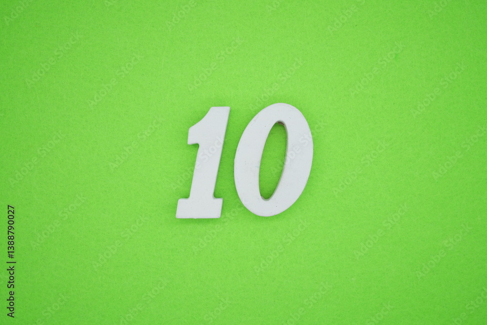 The numbers are made of white painted wood placed on a green paper background. The numbers are made of white painted wood placed on a green paper background.
