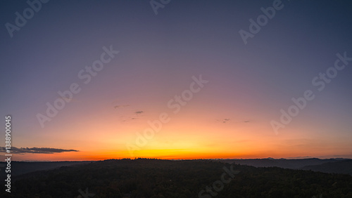 Wallpaper Mural Aerial panorama view  A breathtaking sunset paints the sky with vibrant hues of orange and red, .casting a warm glow over the majestic mountains in a tranquil evening landscape. Torontodigital.ca