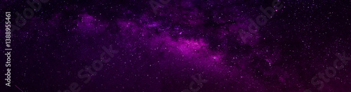 Milky way in night sky and stars on dark background with noise and grain. Long exposure and white balance. Panoramic photo. 