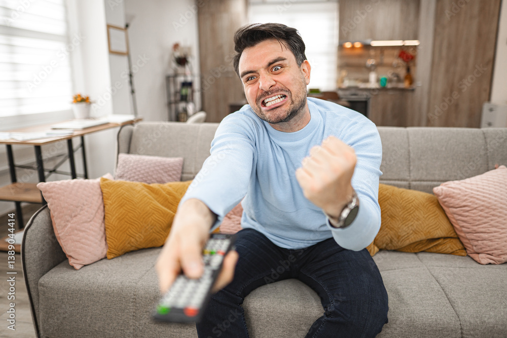 Man Sitting on Couch Holding Remote Control