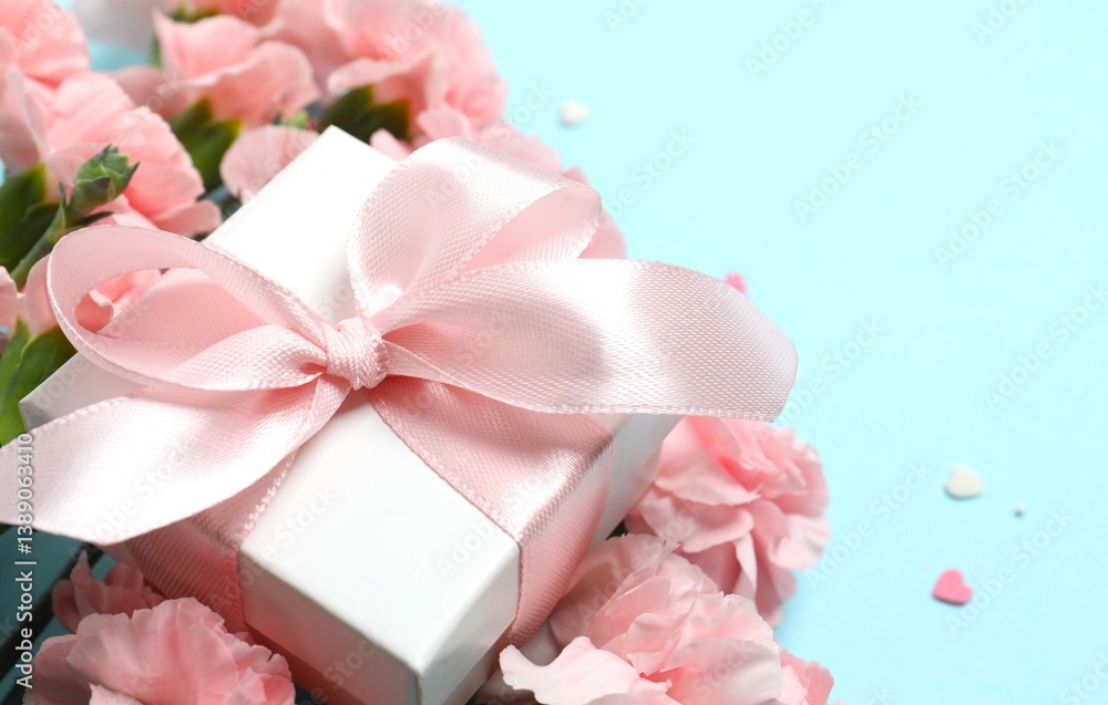 Beautiful bouquet of pink carnations with gift box on a colored background Beautiful bouquet of pink carnations with gift box on a colored background