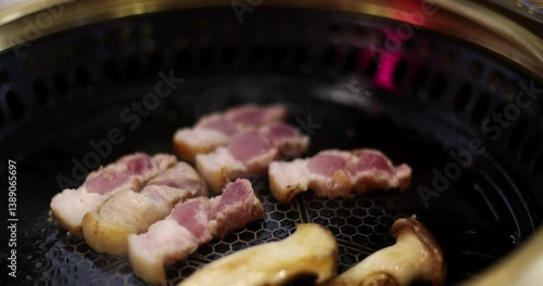 Closeup of Grilling pork belly on Electric stove. Korean style Barbecue (BBQ).
