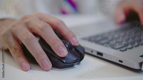 Close-up of freelancer's hand clicking a mouse in a coworking space. Businessman in white shirt and tie works on computer, copywriter editing or writing text while working from home or office setting.