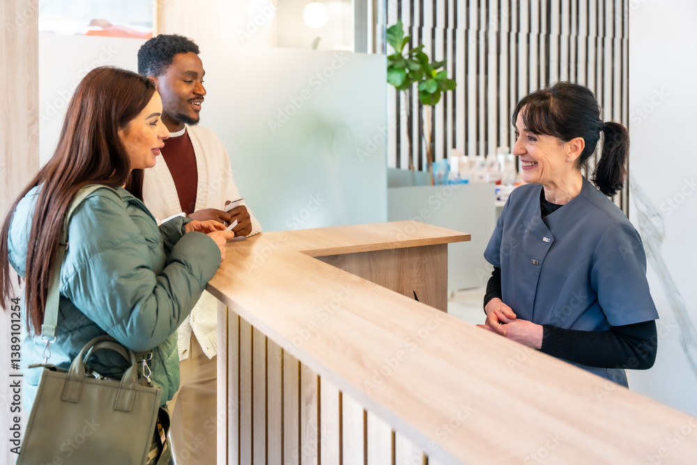 Couple filling medical form at reception desk in dental clinic