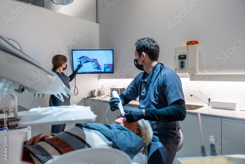 Obraz na płótnie Dentists showing teeth x ray to patient during treatment in modern clinic w salonie